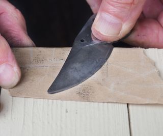 using sandpaper to remove dirt from pruning shears