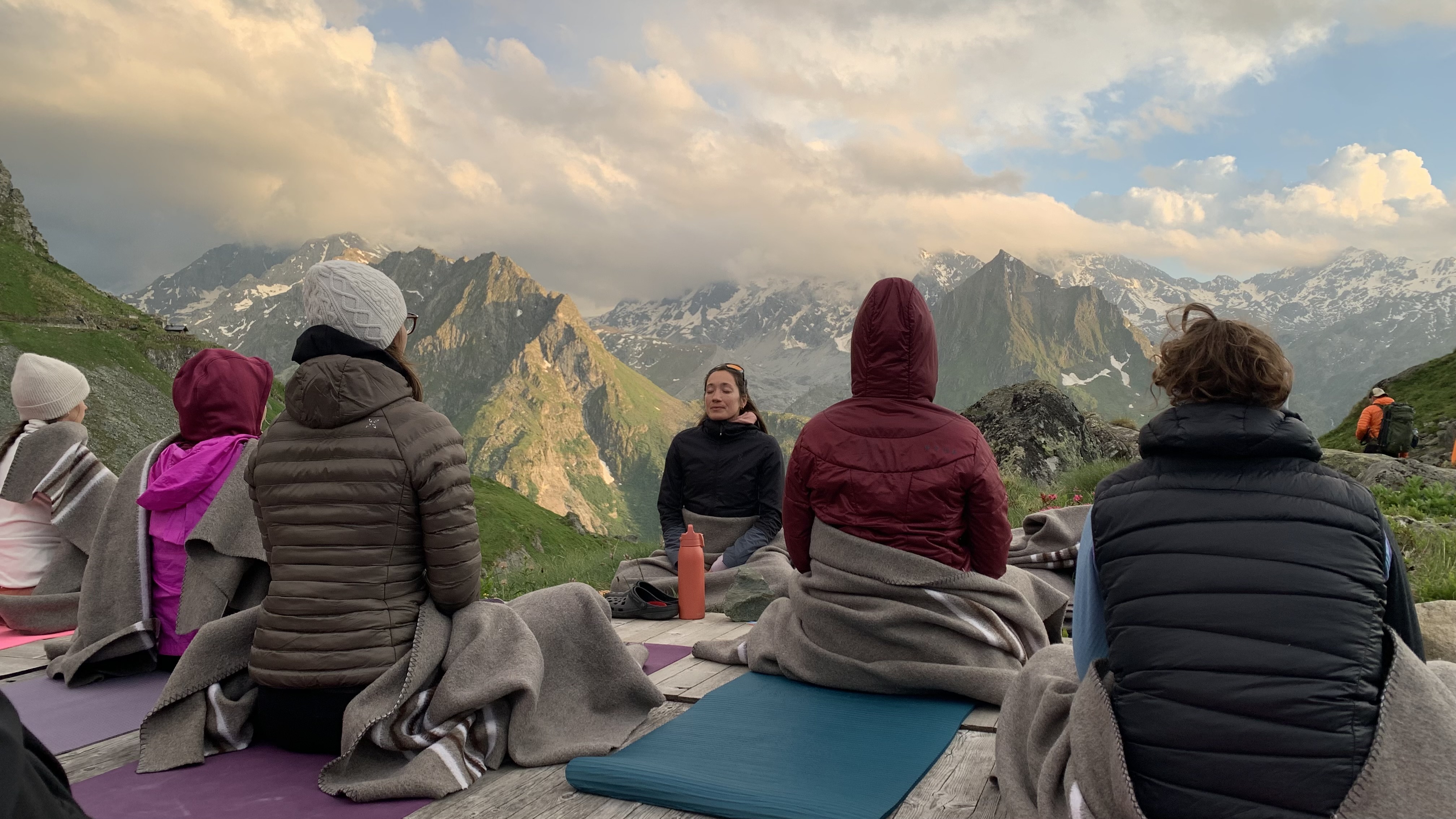 Women practicing meditation in a yoga class in the Swiss Alps