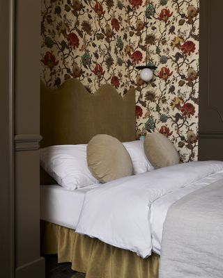 A guest bedroom with floral wallpaper