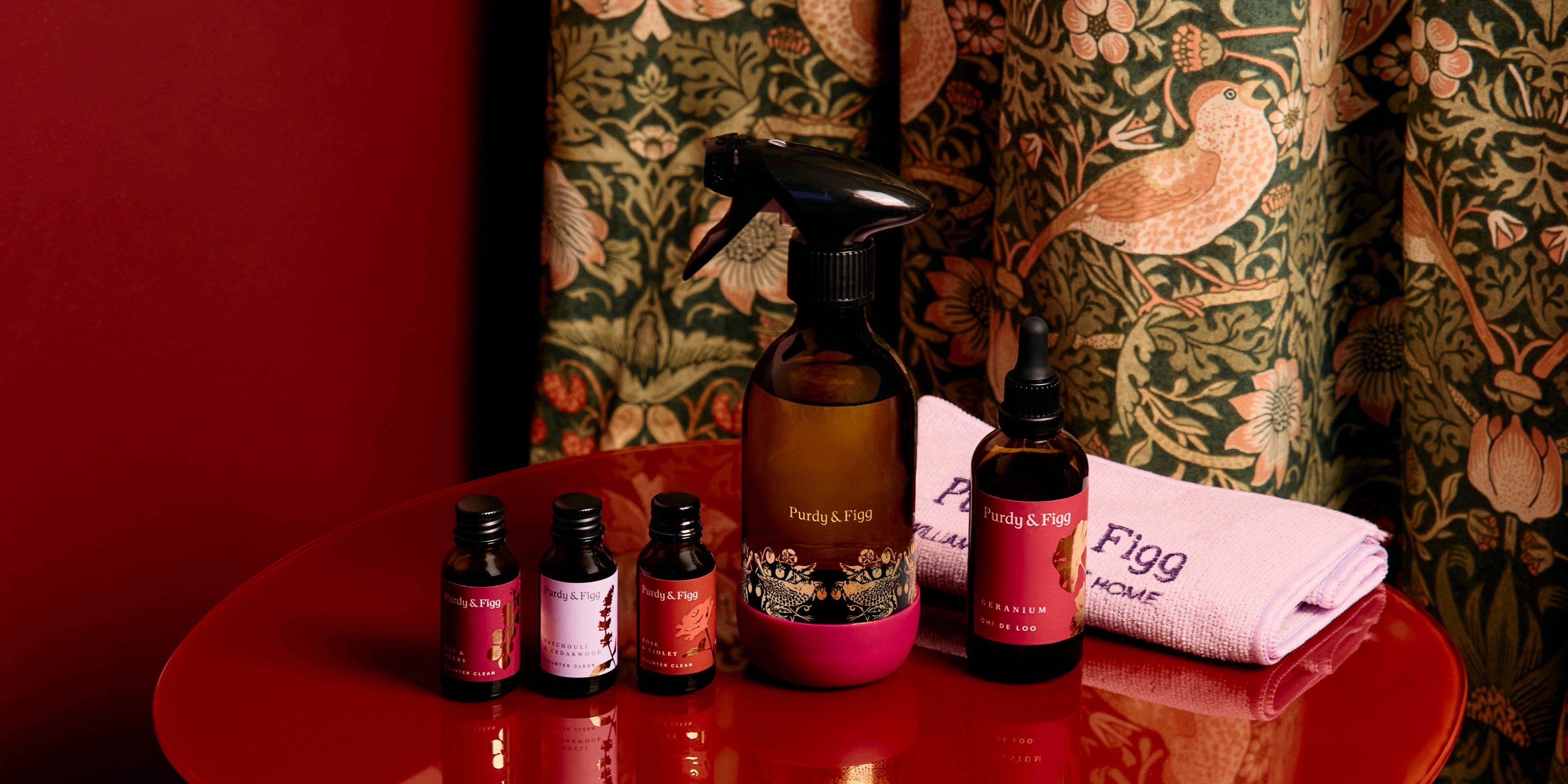 William Morris' limited edition collection with Purdy and Figg, featuring a bottle and three refill scents placed on a red table