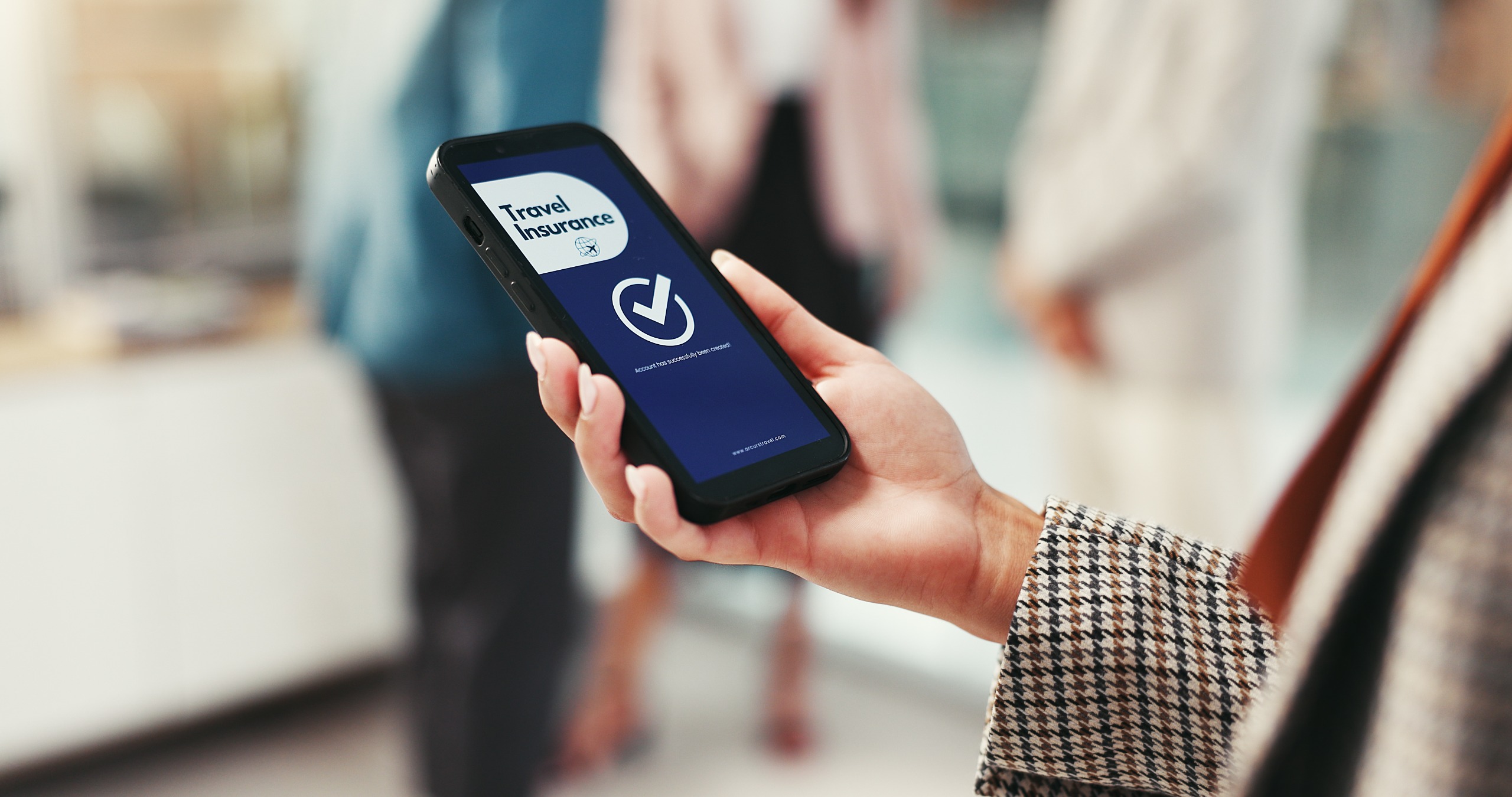 A woman sees a purchase confirmation page on her phone after buying travel insurance.
