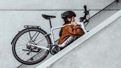 woman carrying Specialized ebike upstairs