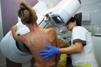 A woman gets a mammogram.