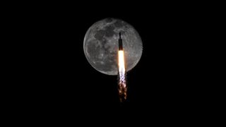 A SpaceX Falcon Heavy rocket transits the full moon during the launch of USSF-52, Dec. 28, 2023.