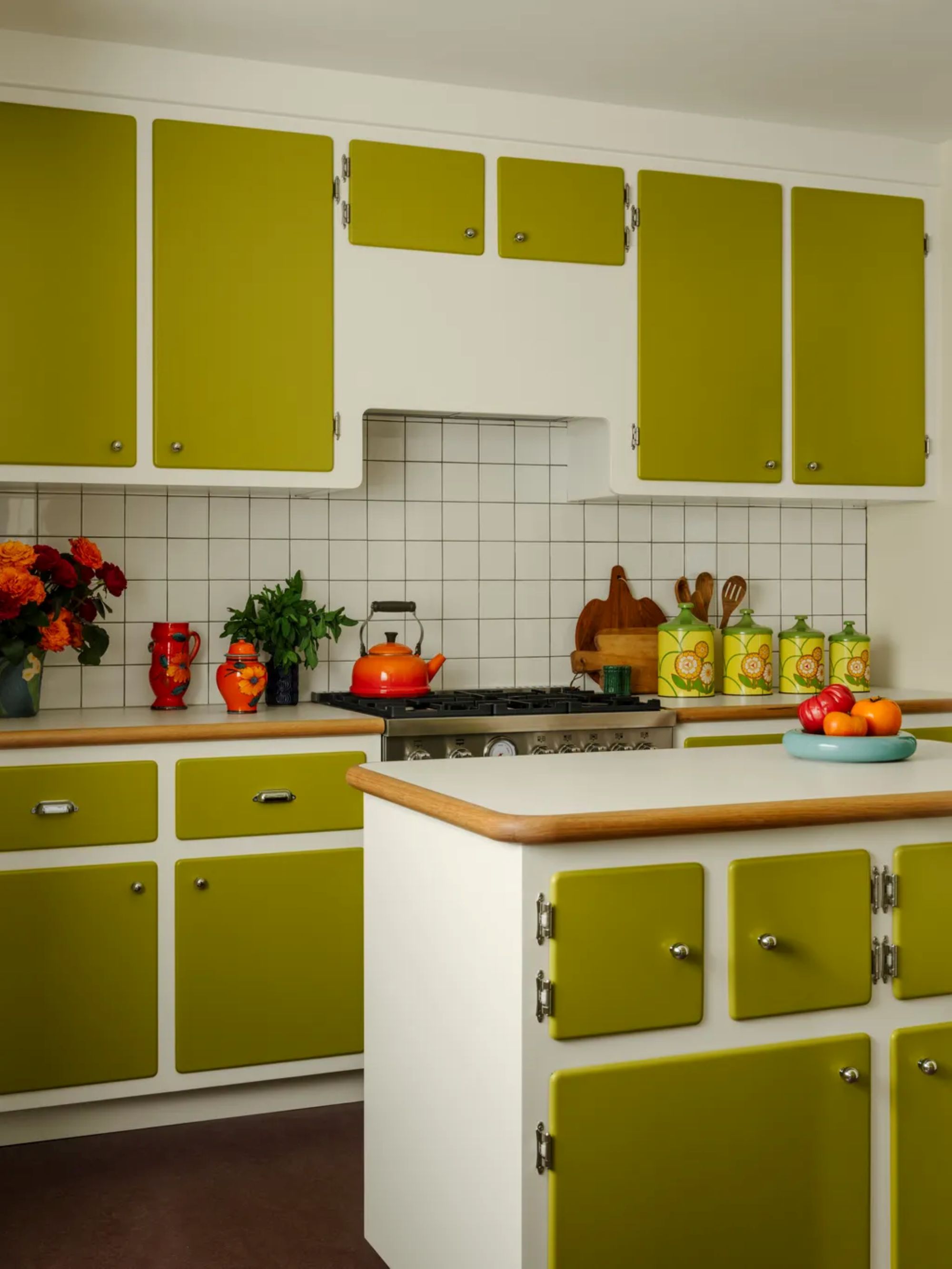 a retro kitchen with rounded cabinets painted in a yellowish green shade on top of a white background