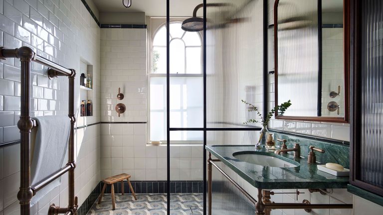 a shower in a bathroom with a patterned tile floor