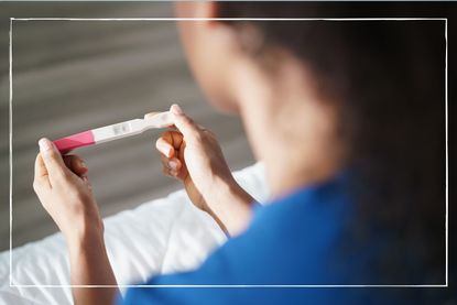 Woman holding a negative pregnancy test 