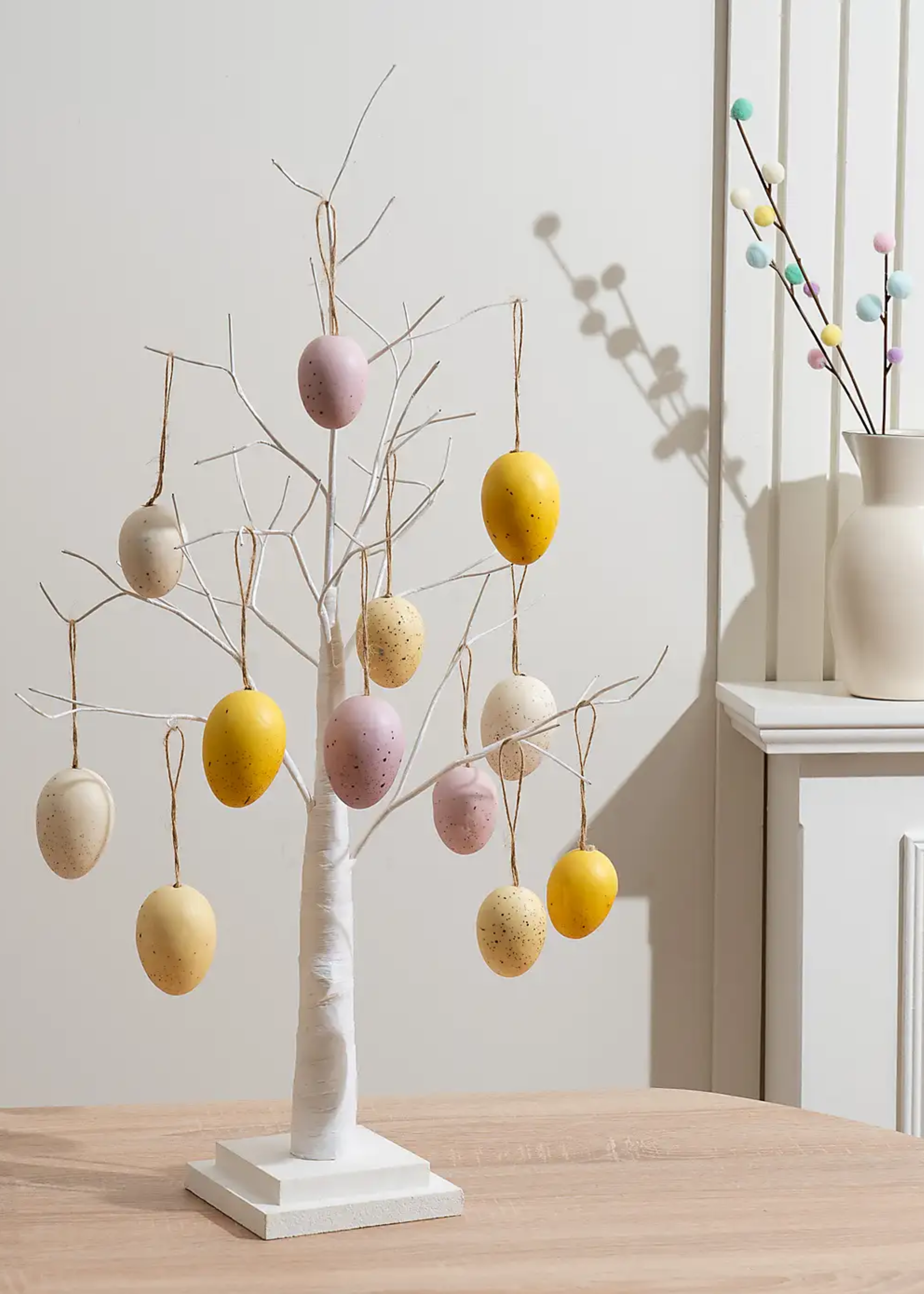 A white twig tree with hanging speckled egg ornaments