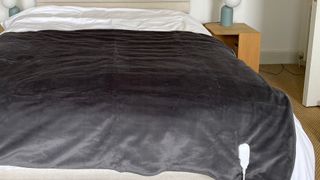 picture of grey electric blanket on double bed with remote at front