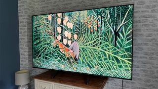 Hisense E7NQ Pro 75-inch 4K TV on wooden dresser with brick wall in background