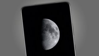 A Samsung Galaxy S21 phone showing a photo of the moon