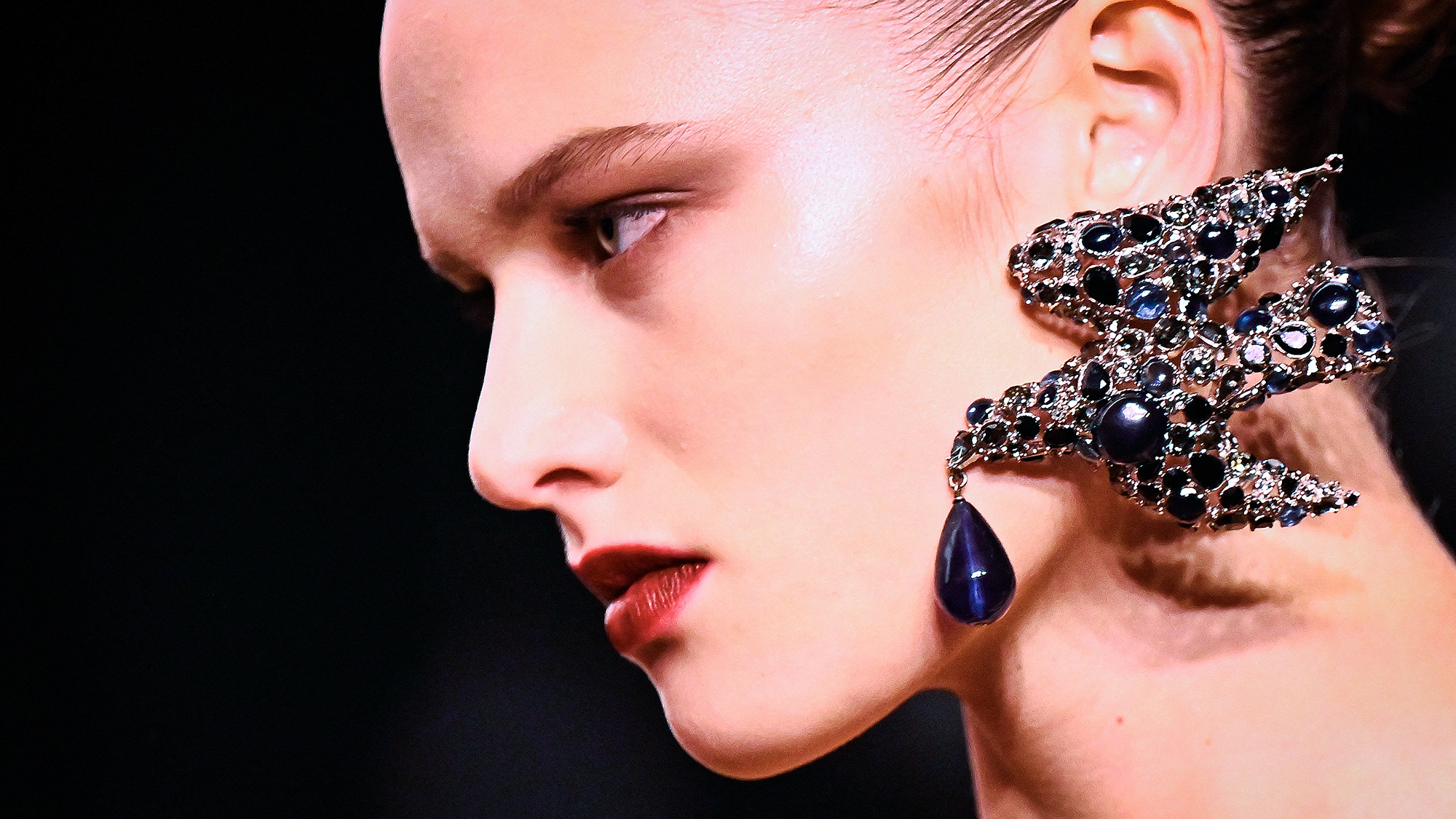 A woman models bird-shaped Saint Laurent earrings during the Fall/Winter 2026-2027 show as part of Paris Fashion Week in Paris, France