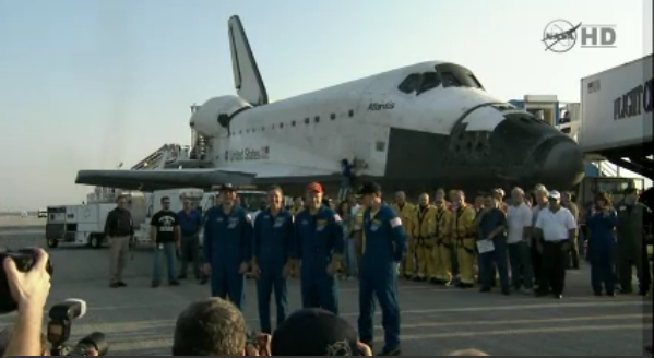 Atlantis&#039; crew stands before the orbiter following a successful landing on July 21, 2011.