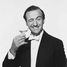 David Niven Holding a Martini Glass and Winking (Photo: John Springer Collection/Corbis via Getty Images.)