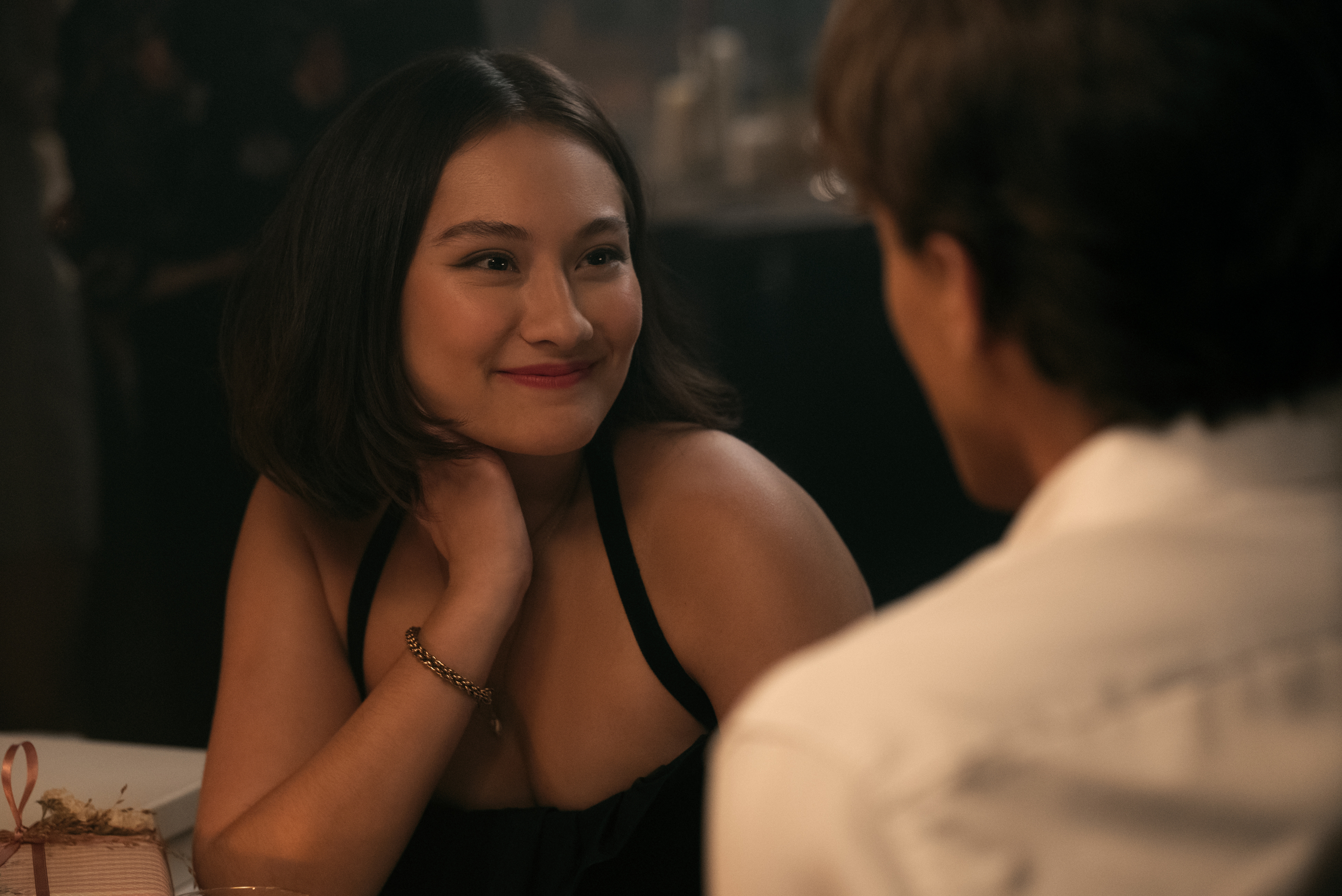 lola tung as belly smiling at conrad while dining in paris in the summer i turned pretty season 3