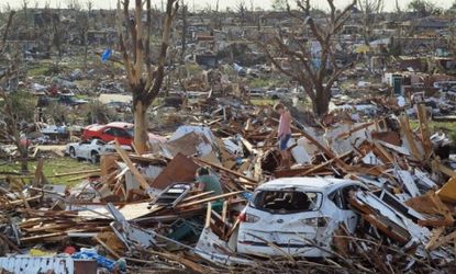 A Missouri mother and daughter pick through the wreckage left by a deadly tornado: A recent string of killer storms has environmentalists blaming climate change.