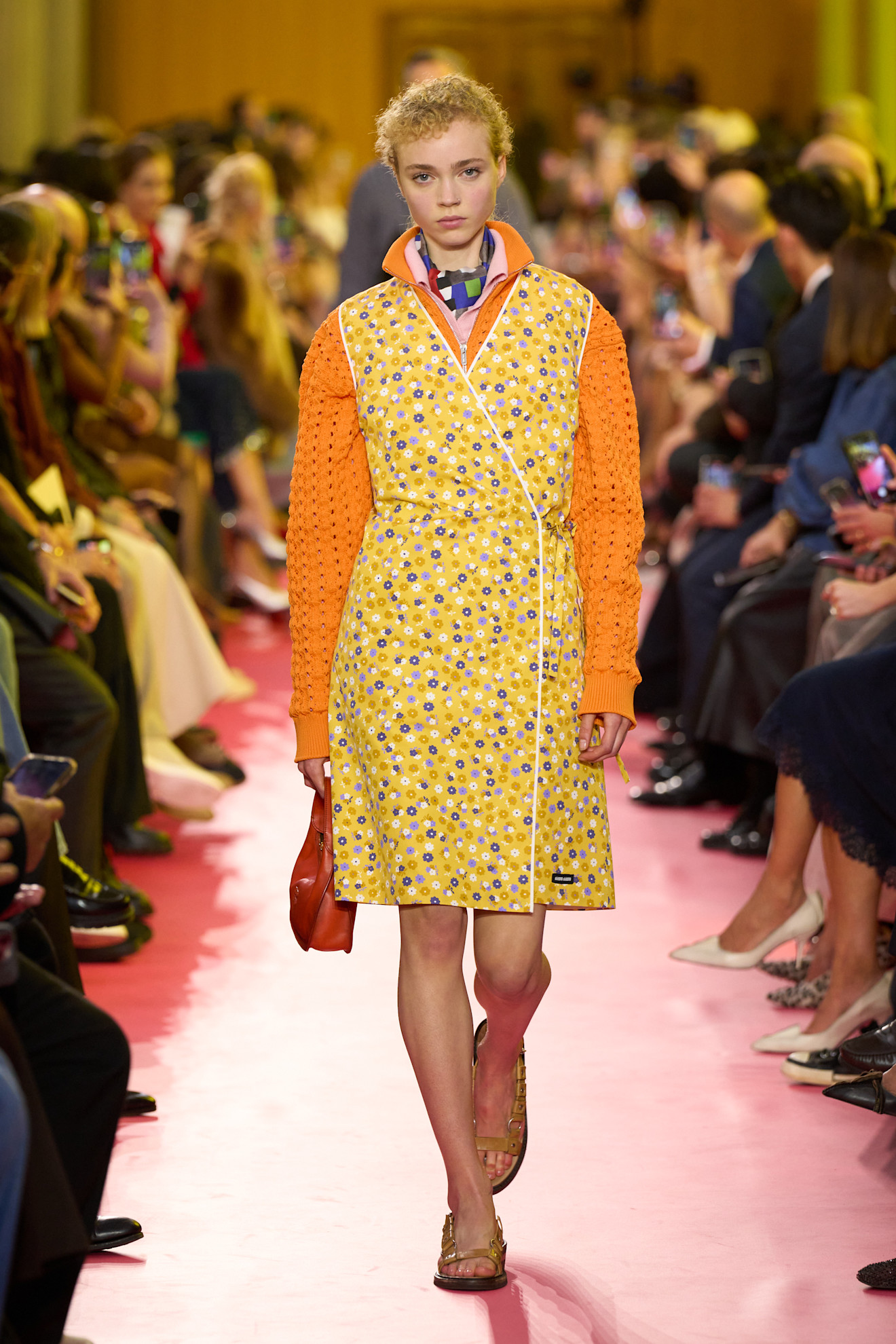 Woman in a sweater and apron on the Miu Miu runway