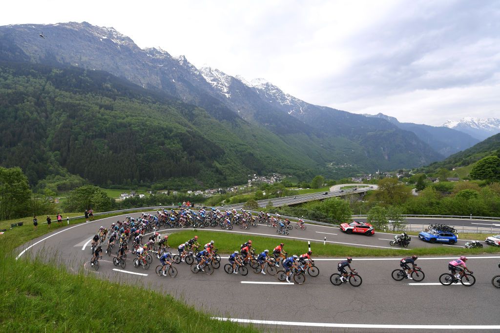 VALLE SPLUGA ALPE MOTTA ITALY MAY 29 Egan Arley Bernal Gomez of Colombia and Team INEOS Grenadiers Pink Leader Jersey The peloton passing through Mesocco mountains 792m landscape during the 104th Giro dItalia 2021 Stage 20 a 164km stage from Verbania to Valle Spluga Alpe Motta 1727m Colombian Fans Snow Alps Switzerland CHE UCIworldtour girodiitalia Giro on May 29 2021 in Valle Spluga Alpe Motta Italy Photo by Tim de WaeleGetty Images