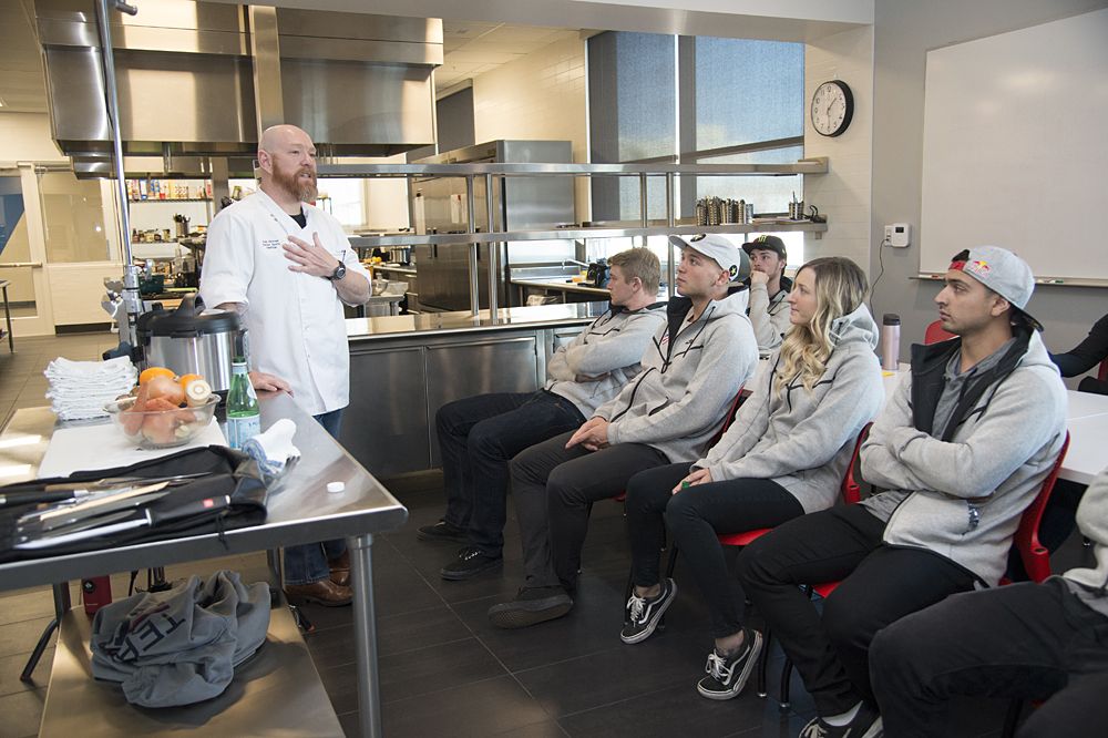 Riders listen to a USOC chef about dietary services offered to team members.