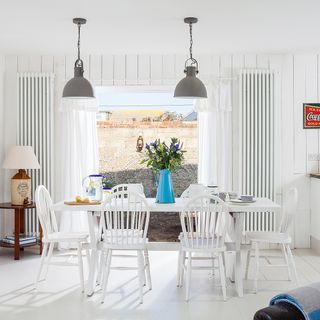 dining room with white tiled flooring and white walls
