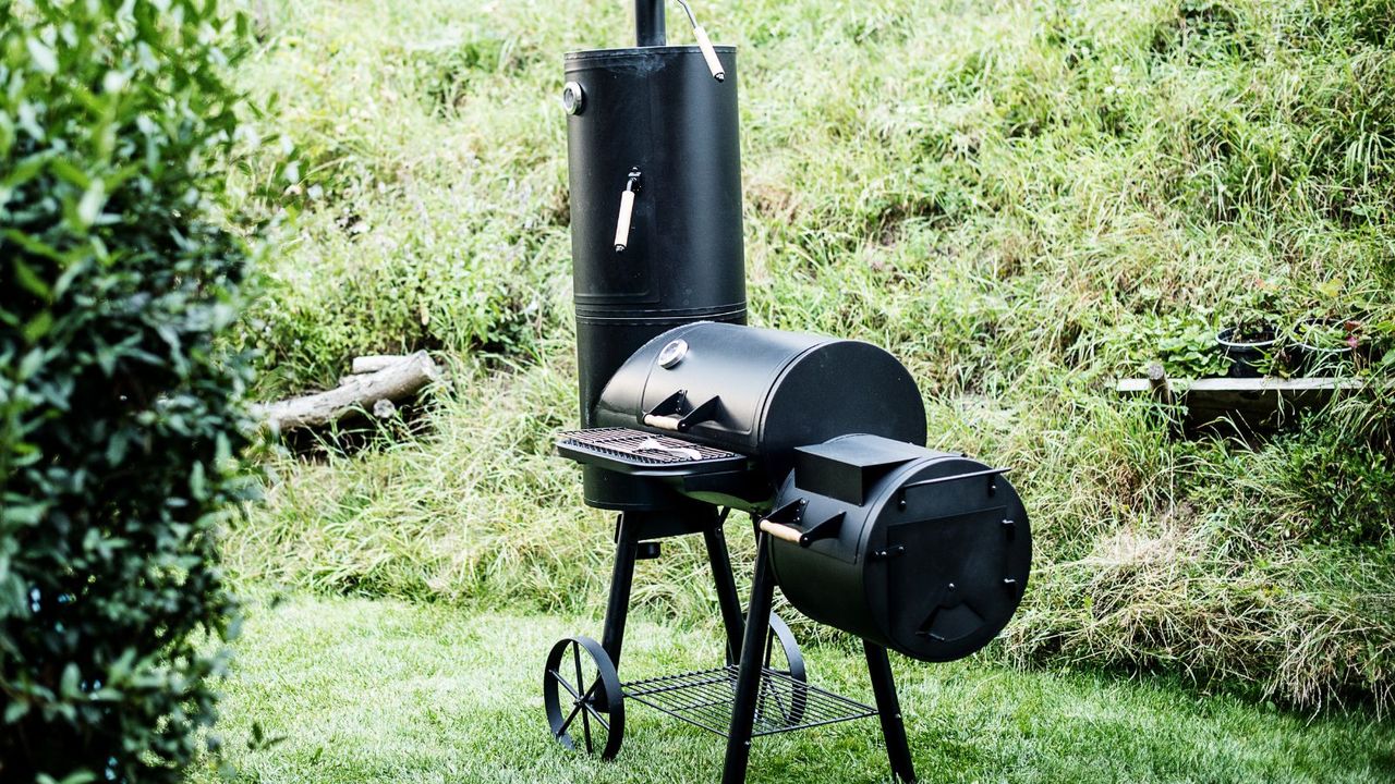 An offfset and chimney smoker in a yard