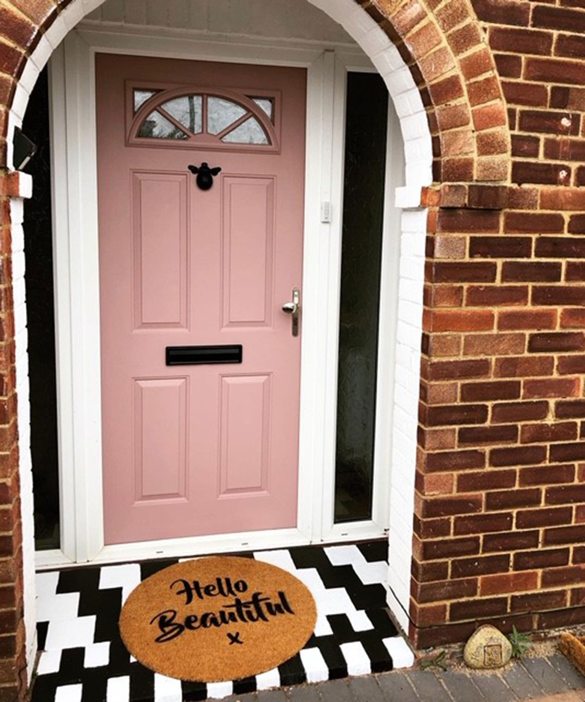 Pink front door with black and white doorstep