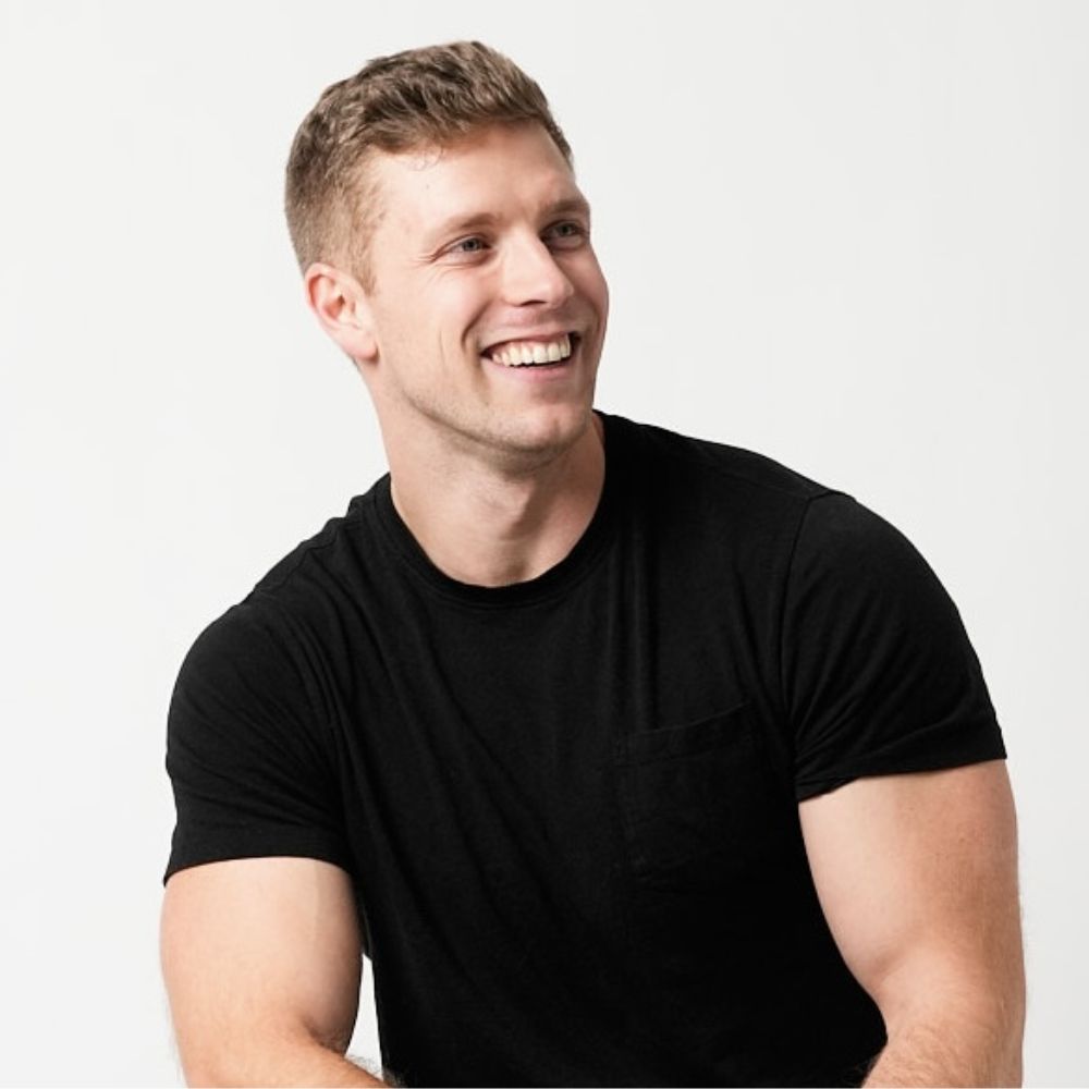 A headshot of Ryan Meagher wearing a black top against a white background