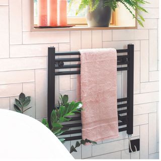 black radiator on pink bathroom wall tiles