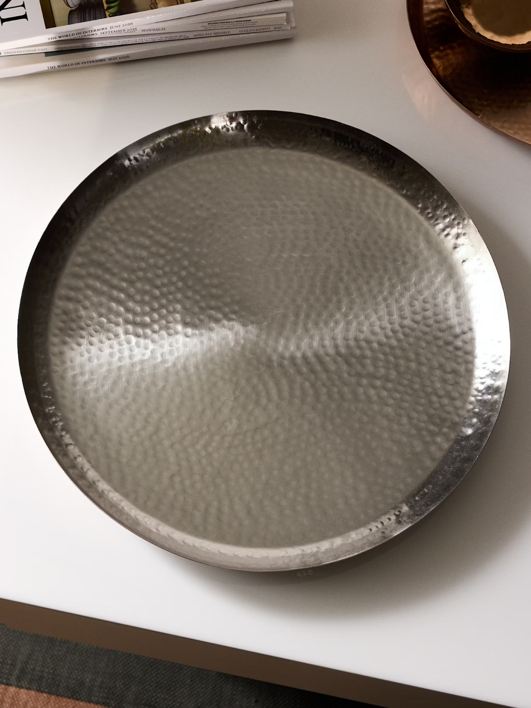 A textured round iron tray from Mango