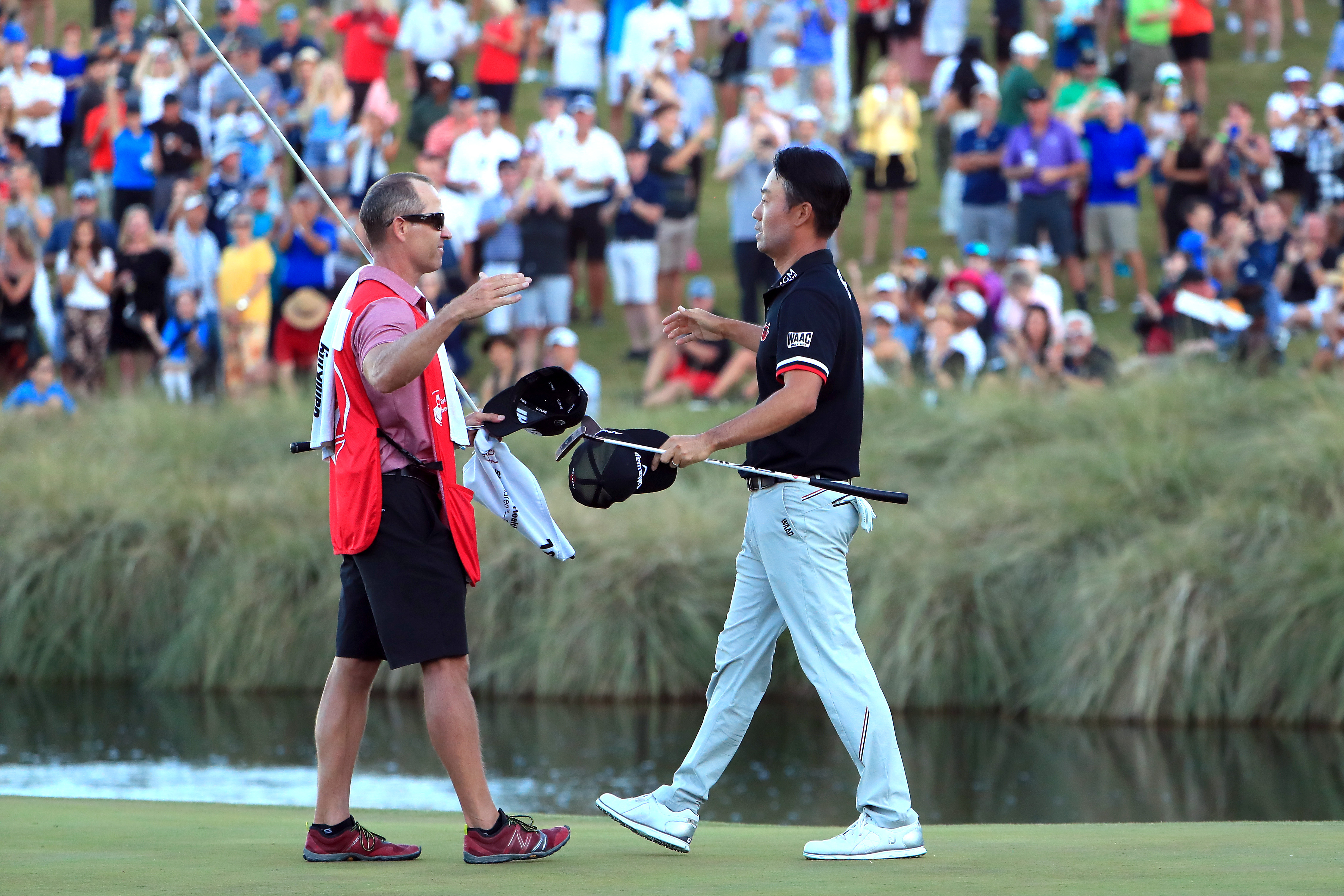 Kenny Harms and Kevin Na embrace after victory in 2019