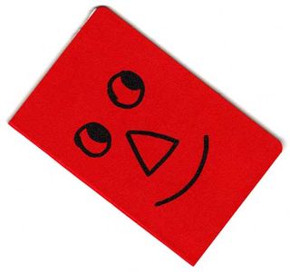 A red journal cover with a smiley face on its cover.