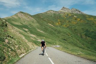 The Orbea Orca shown ridden on a tarmac road with mountain in the background