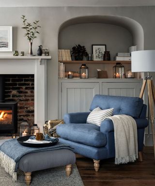 Blue armchair, grey fireplace and cabinets