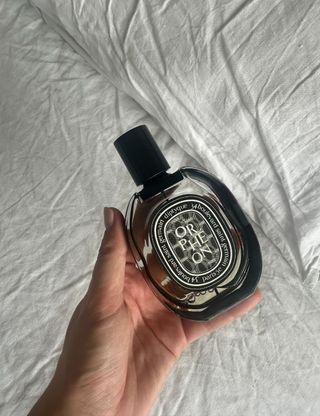 Beauty director, Shannon Lawlor, holding one of the best perfumes, Diptyque Orphéon