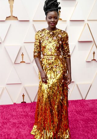 Lupita Nyong'o in a gold sequin gown on the red carpet