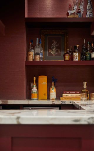 a home bar with red grasscloth wallpaper