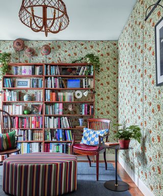 study with patterned wallpaper, wooden bookcase and striped ottoman
