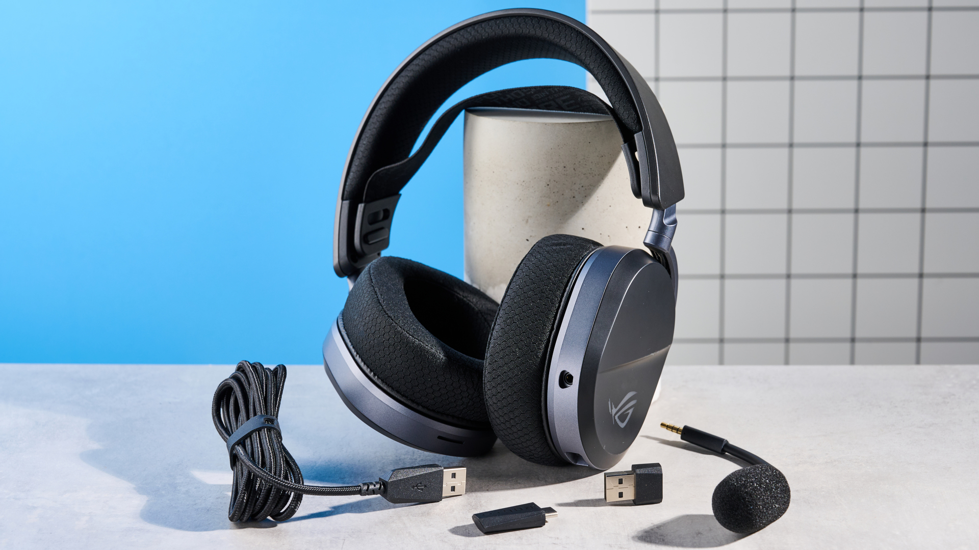 A black Asus ROG Pelta gaming headset with a detachable mic and RGB lighting