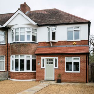 house with lawn and brick wall