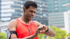 A runner checking his fitness watch during a heart rate training run