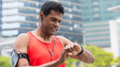 A runner checking his fitness watch during a heart rate training run