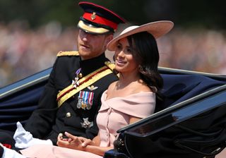 Prince Harry, Duke of Sussex and Britain's Meghan, Duchess of Sussex return in a horse-drawn carriage after attending the Queen's Birthday Parade, 'Trooping the Colour' on Horseguards parade in London on June 9, 2018