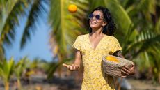 Young woman holding a fruit basket at the beach, Costa Rica - stock photo