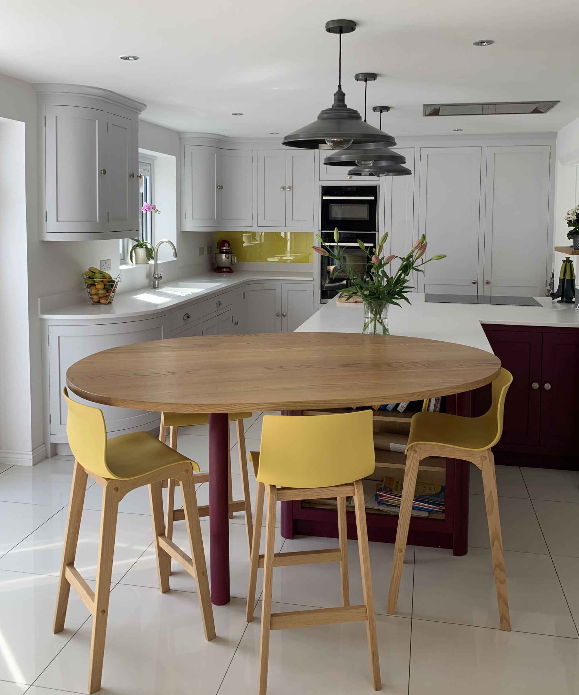 tall round kitchen table with yellow upholstered stools at end of kitchen island