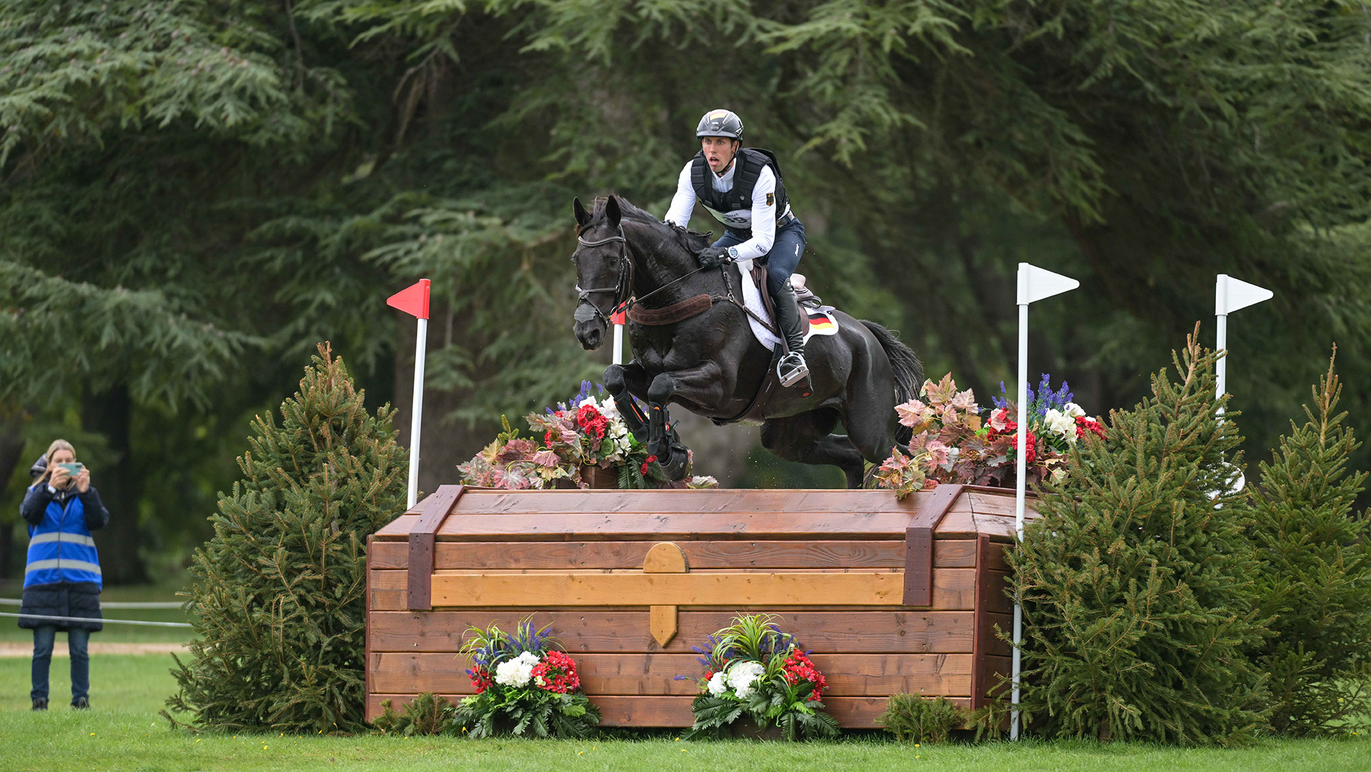 Germany's J&eacute;r&ocirc;me Robin&eacute; and Black Ice clear a large wooden chest at the Blenheim European Eventing Championships 2025.