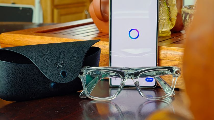 Transparent Ray-Ban Meta Smart Glasses with transitions lenses next to the glasses charging case and the Meta AI app