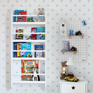 white shelf with toys in a room with white walls and blue star wallpaper