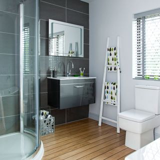 bathroom with ladder towel rack and wooden floor and washbasin
