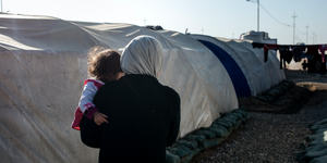 Woman holding baby in Iraqi camp