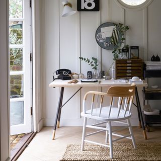 outdoor room with white wall and wooden table and chair